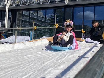 ソリ遊びをするメトコちゃん親子