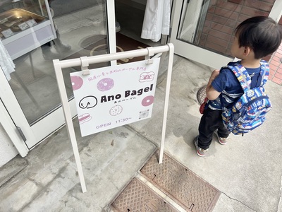 Ano Bagelの看板と入店を待つ「いととこナカノ」さんの息子さん