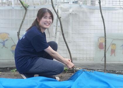 保育士職の職員が砂場の設営をしている写真