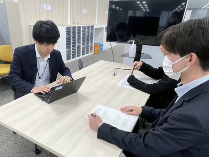 事務職の職員が同僚と会議をしている写真