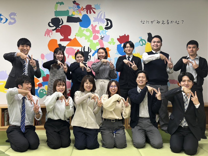 事務職の職員と同僚たちとの記念写真